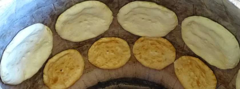 Brot backen an der Innenwand eines traditionellen Tone‑Ofens